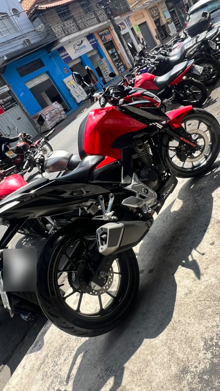 Moto vermelha estacionada na porta da loja, na Rua Tiradentes